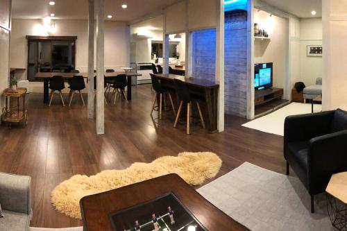 a living room with a couch and a table with chairs at Riders Ridge Luxury Chalet sleeps 12 Ski In Ski Out Myoko in Akakura