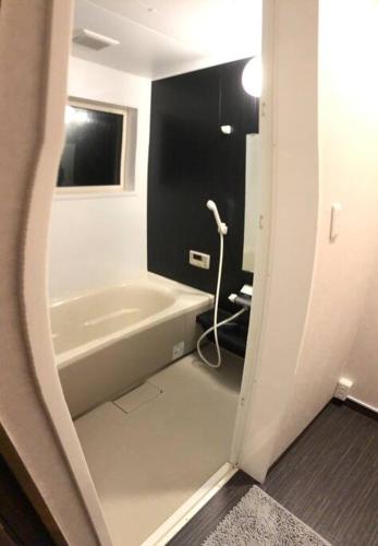 a bathroom with a bath tub and a sink at Riders Ridge Luxury Chalet sleeps 12 Ski In Ski Out Myoko in Akakura