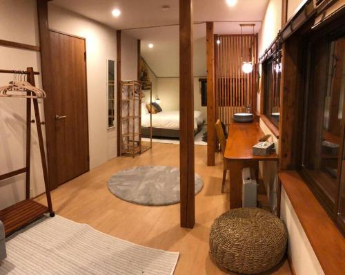 a room with a desk and a bedroom with a bed at Riders Ridge Luxury Chalet sleeps 12 Ski In Ski Out Myoko in Akakura