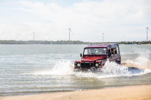a jeep driving through the water on the beach at Club Mango Resort in Kalpitiya
