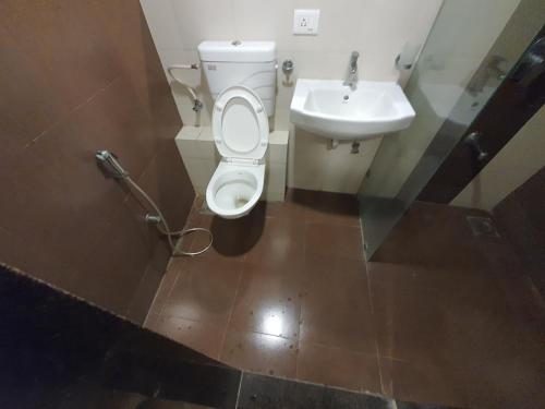 a bathroom with a toilet and a sink at P C Homes at Belliza near airport in Surat