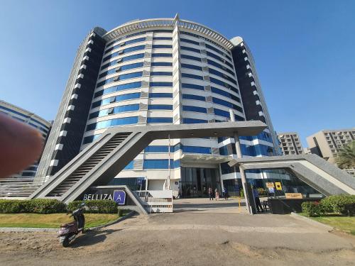 a large tall building with a person in front of it at P C Homes at Belliza near airport in Surat