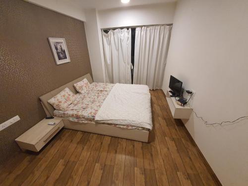 a small bedroom with a bed and a window at P C Homes at Belliza near airport in Surat
