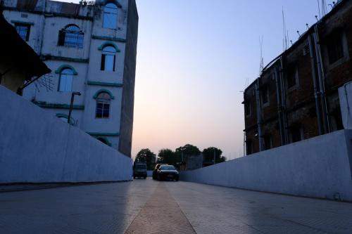 a car driving down a street near a building at Hotel Girija Sunrise 300 Meter from Baba Dham Temple in Deoghar