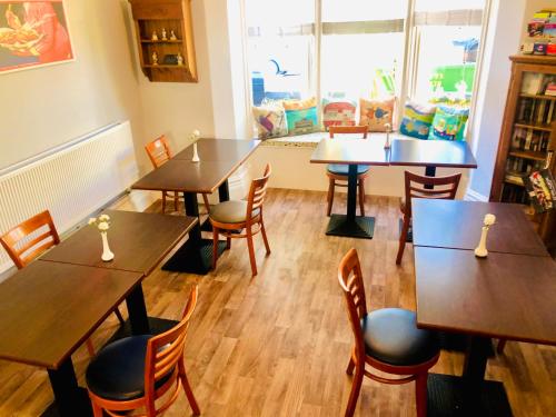 ein Restaurant mit Holztischen und -stühlen und einem Fenster in der Unterkunft Mulberry House in Llandudno