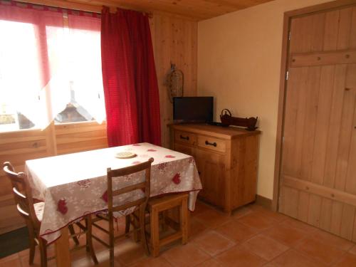a dining room with a table and a television at Appartement les 4 Monts in Megève