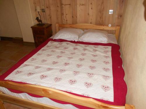 a bedroom with a bed with a white and red blanket at Appartement les 4 Monts in Megève