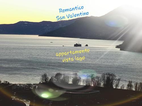 a view of a lake with a boat in the water at Sole & Lago-Lake in Maccagno con Pino e Veddasca