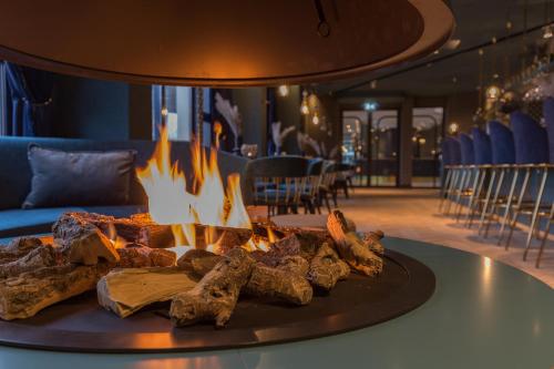 a plate of food on a table with a fire at Van der Valk Hotel Venlo in Venlo