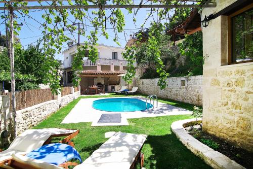 a backyard with a swimming pool and a house at Alexander Villa in Gouledhianá