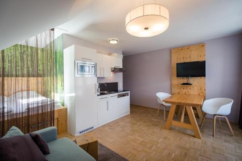 ein Wohnzimmer mit einer Küche und einem Tisch mit einem Esszimmer in der Unterkunft Apartments Alpenpark Turrach by ALPS RESORTS in Brandstätter