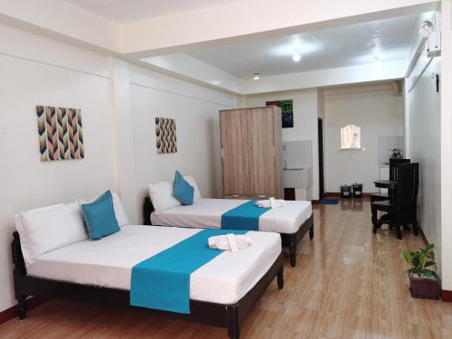 a hotel room with two beds and a desk at JPrime Apartelle in Tuguegarao City