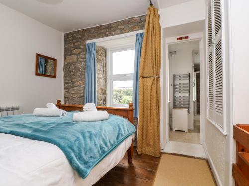 a bedroom with a bed and a window at Lowena in Penzance