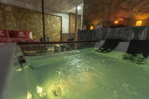 a hot tub in a room with green water at Onore dell amore 2 apartman sa djakuzijem in Banja Koviljača