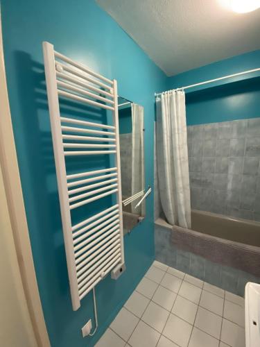 La salle de bains est pourvue d'un mur bleu et d'un porte-serviettes. dans l'établissement Le Soleil Levant, à Les Sables-dʼOlonne