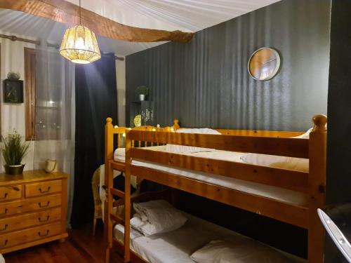 1 Schlafzimmer mit 2 Etagenbetten und einem Kronleuchter in der Unterkunft la grange avec bain nordique et sauna en pleine montagne in Arrens-Marsous