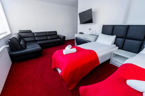 a bedroom with a red carpet and a bed and a couch at Stacja Snu in Bytów