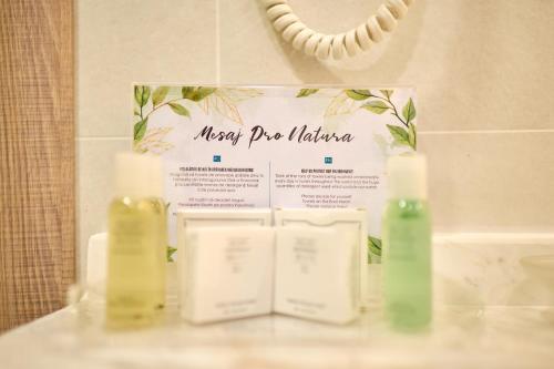 a sign in a bathroom with two soap bottles at Hotel Malibu in Mamaia