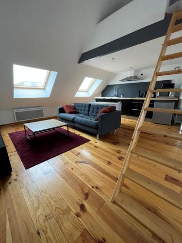 - un salon avec un canapé et une échelle dans l'établissement Style loft au pied du Tramway, à Aulnoy
