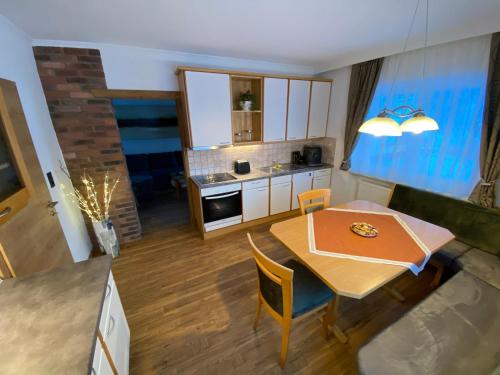 cocina pequeña y comedor con mesa y sillas en Ferienwohnung Wildkogelblick, en Bramberg am Wildkogel