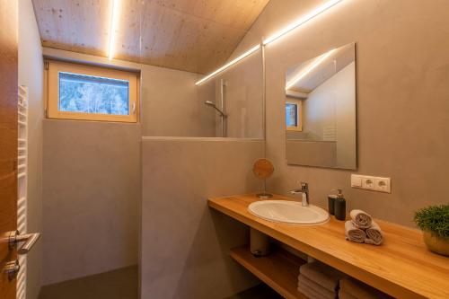 ein Bad mit einem Waschbecken und einem Spiegel in der Unterkunft Gauensteiner Hof in Schruns-Tschagguns