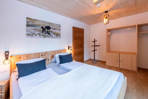 a bedroom with a bed and a cross on the wall at Gauensteiner Hof in Schruns-Tschagguns