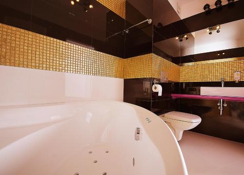 La salle de bains est pourvue d'une baignoire blanche et de toilettes. dans l'établissement Zajazd Sebory, à Romany Sebory