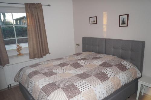een slaapkamer met een bed met een quilt bij Haus Wattenblick EG in Morsum