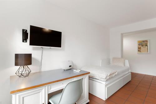 a room with a desk with a bed and a tv at Cozy Boutique Apartment at Mt. Rigi in Goldau