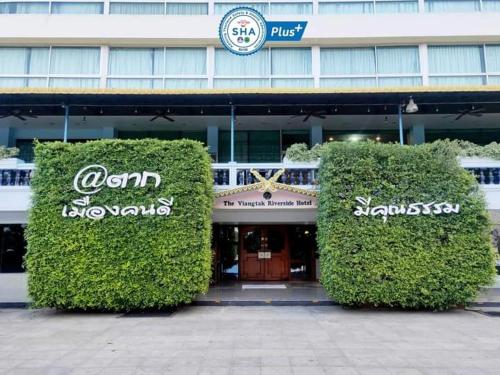 two large hedges in front of a building at Viang Tak Riverside Hotel in Tak