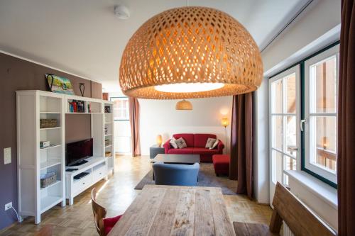ein Wohnzimmer mit einem roten Sofa und einem großen Kronleuchter in der Unterkunft Apartments Alpenpark Turrach by ALPS RESORTS in Brandstätter
