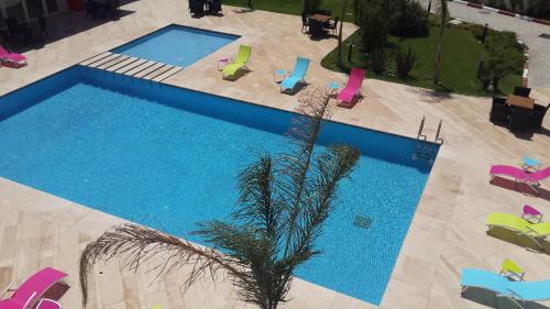 an overhead view of a swimming pool with chairs and a palm tree at Ramada Encore By Wyndham Tangier in Tangier