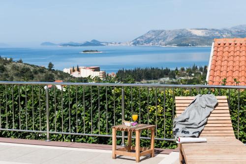 a chair on a balcony with a view of the water at Apartments Bell Memories in Cavtat