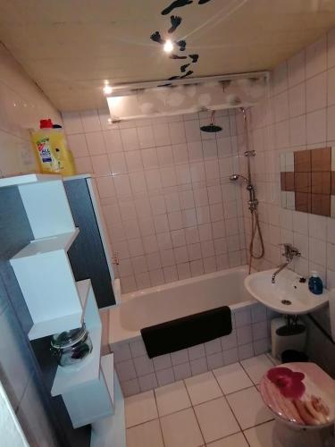 y baño con lavabo, bañera y aseo. en schöne Ferienwohnung über den Dächern von Plauen, en Plauen