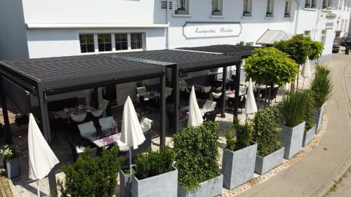 an outdoor restaurant with white umbrellas and tables at Landgasthof Hirschen in Hohentengen