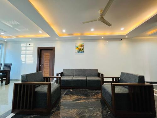 a living room with couches and a ceiling fan at Coorg ASHOK PALACE in Madikeri