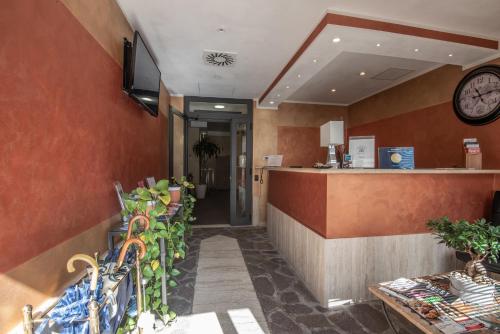a restaurant with a counter and a clock on the wall at Hotel Petra in La Romanina