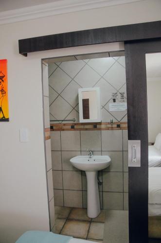 a bathroom with a sink and a mirror at Towers Lodge in Boksburg