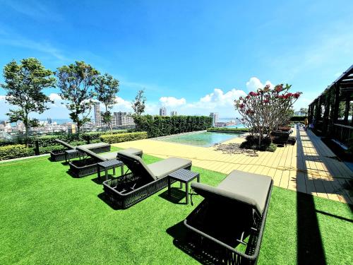 a row of tables and chairs on a lawn with a pool at Beacon Executive Suites in George Town