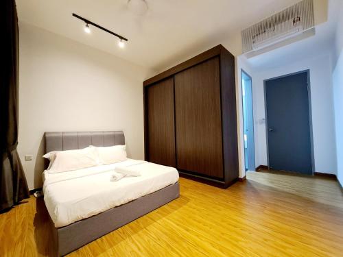 a bedroom with a bed and a wooden floor at Beacon Executive Suites in George Town