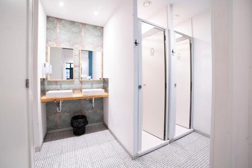 een badkamer met 2 wastafels en een spiegel bij Koba Hostel in San Sebastian
