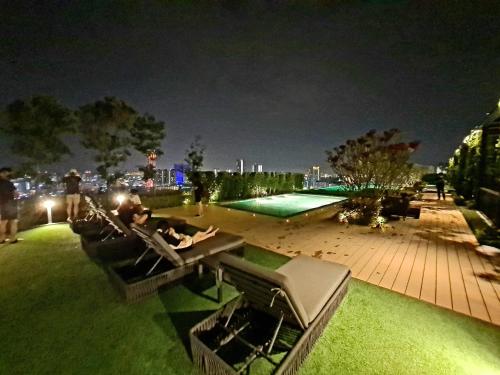 a person sitting in a chair on a patio at night at Beacon Executive Suites in George Town