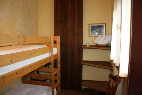a room with two bunk beds and a window at HG Hotel La Caminatha in Val di Zoldo