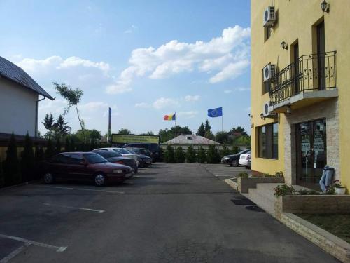 a parking lot with cars parked next to a building at MOTEL COOL in Bărcăneşti