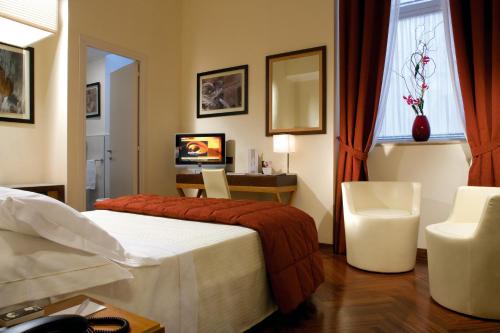 a hotel room with a bed and a desk and a television at Hotel Nazionale in Rome