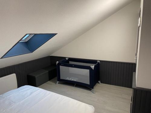 Cette chambre mansardée comprend un lit et une télévision. dans l'établissement Appartement Yuandudu, à Noyers-sur-Cher