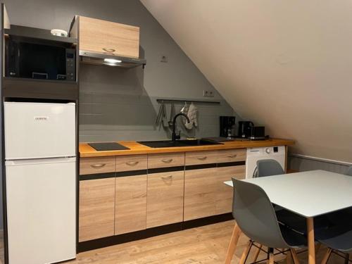 une cuisine avec un réfrigérateur blanc et une table dans l'établissement Appartement Yuandudu, à Noyers-sur-Cher