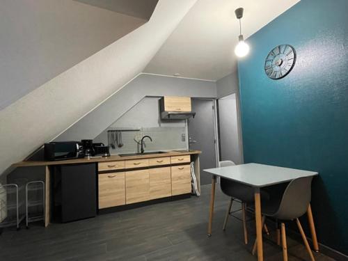 une cuisine avec une table et une horloge au mur dans l'établissement Appartement Huanlili, à Noyers-sur-Cher