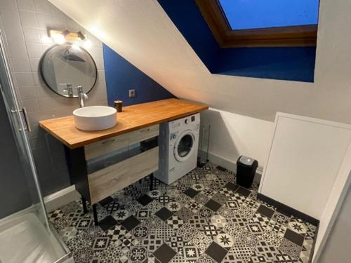 une salle de bain avec un lavabo et une machine à laver dans l'établissement Appartement Huanlili, à Noyers-sur-Cher
