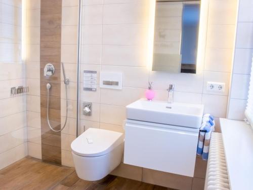 a bathroom with a toilet and a sink and a shower at Gasthof Landhotel Hirsch in Ostrach
